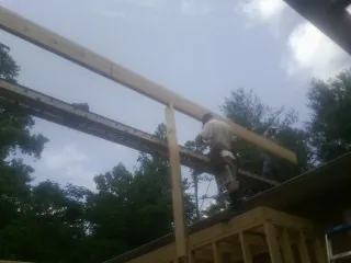 Carpenter setting a ridge beam over a new addition frame — Ice Dam Removal by Roofing Brothers in Joy