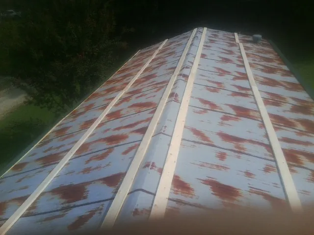 Rusted metal roof panels with new wood purlins before replacement — Storm Damage Roof Repair in Joy by Roofing Brothers