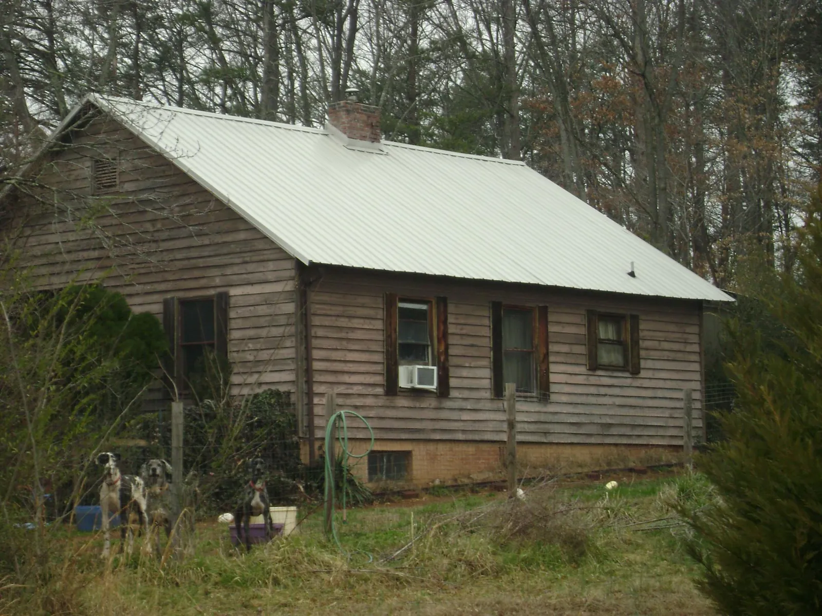White metal roof on an old wood sided farmhouse, from a Metal Roof Installation job in Joy